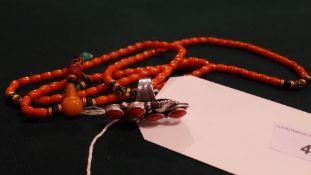A silver and coral ring together with a coral beaded necklace