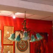 A large French gilt metal five branch chandelier with green irridescent glass shades