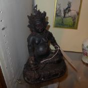 A Tibetan cast iron figure of a seated Buddha