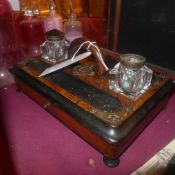 A Victorian figured walnut and ebonised inkstand with two glass inkwells and a single drawer