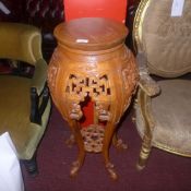 A Chinese carved hardwood jardiniere stand terminating on swept supports united by undertier