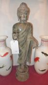 A large bronze figure of Buddha raised on a circular base