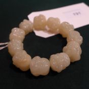 A Chinese jade bracelet carved with Buddha heads