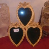 A gilt metal triple phototgraph frame of heart form on easel supports