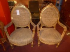 A pair of French armchairs in carved giltwood show frames and upholstered in damask on turned