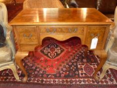 A burr walnut kneehole writing table fitted three drawers raised on cabriole supports
