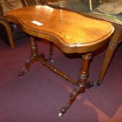 A Victorian inlaid stretcher table of serpentine outline raised on carved supports