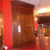 A Georgian oak corner cabinet fitted single panel door