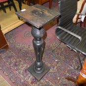 An ebonised torchere