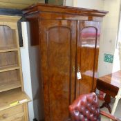 A Victorian walnut double arched panel doors wardrobe raised on plinth base