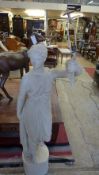 A large plaster painted statue of Goddess Diana with outstretched arm holding torch