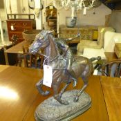 A bronze cast of polo player on oval base