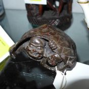 An antique Chinese carved hardwood  figure of a buddha under a tortoishell