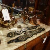 A collection of copper and brass items including kettles and horse brass