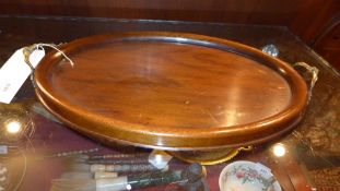 A mahogany twin handled tray of oval form and with inset glass top
