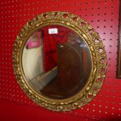 A pierced giltwood circular mirror with bevelled plate