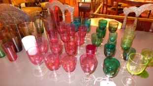 A large collection of coloured drinking glasses and similar items