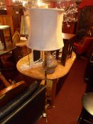 A brass standard lamp with white silk shade