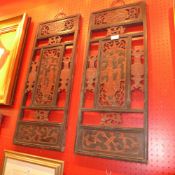 A pair of carved Chinese wooden panels decorated with figures