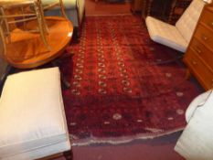 A Persian carpet of large size with rouge field and decorated with repeating motifs 305 x 265 cm