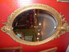 A C19th French wall mirror the oval plate within giltwood frame with beaded detail