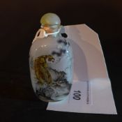 A Chinese reverse painted snuff bottle decorated with a landscape scene with tigers