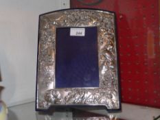 A hallmarked silver photograph frame decorated in the Japanese manner with a pagoda, birds and
