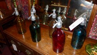 A set of six soda syphon style bottles in various coloured glass