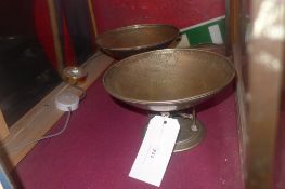 A pair of planished silver plated bowls raised on four supports on a circular base