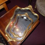 A pair of Italian cartouche form gilt framed mirrors of graduating size