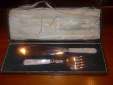 A cased hallmarked silver set of fish servers with another of pearl handles