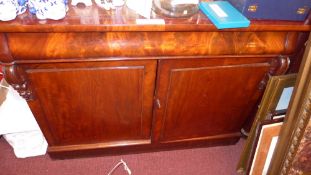 A Victorian mahogany side cabinet the leather lined top above frieze drawer and pair of panel