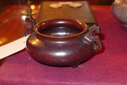 A Chinese twin handled incense burner raised on three proportions