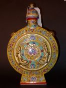 A Chinese lidded moon flask decorated in yellow glaze and heightened in gilt