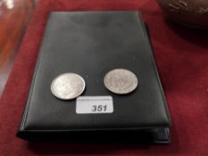 A collection of various white metal replica coins