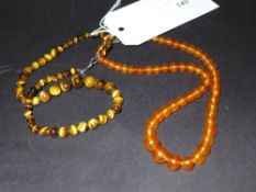 A tigers eye beaded necklace together with an amber beaded necklace