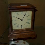 A fruitwood cased mantle clock, with pendulum