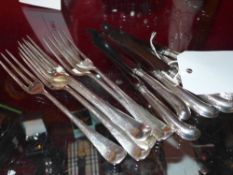 A set of six hallmarked silver handled pistol grip butter knives together with six silver plated