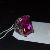 A sterling silver ring set with a large pink stone