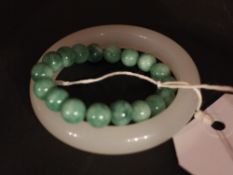 A Chinese jade bangle and a jade beaded bracelet