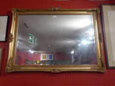 A rectangular wall mirror with bevelled plate and in swept giltwood frame together with a glazed and