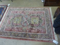 A Madras rug the rouge field with double pole medallion in single border