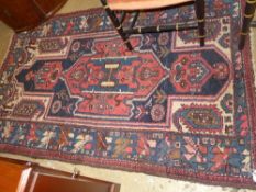 A hand knotted Hamadan rug the red ground with stylized decoration