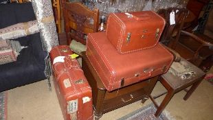 A pair of tan leather suitcases and a va