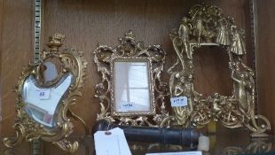 A collection of gilt metal frames and a dressing mirror with clock aperture