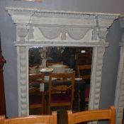 A distressed painted overmantle mirror the carved frieze above rectangular plate