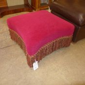 A Victorian ebonised footstool upholstered in red velour raised on castors