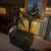 A bronze cast of kick boxers on marble b
