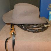 A leather whip with solid handle and a cowboy hat. Whip Length 295 cm