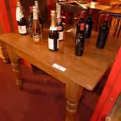 A Victorian pine kitchen table with rectangular top raised on turned supports